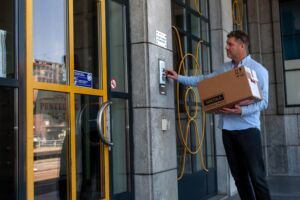 Koerier van Your Couriers die aanbelt met pakket in hand